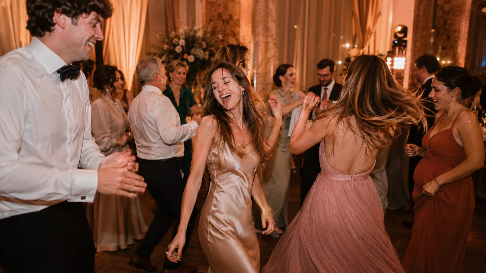 Volle Tanzfläche bei einer Hochzeit in Bayern, bunte Lichtstimmung, feiernde Gäste