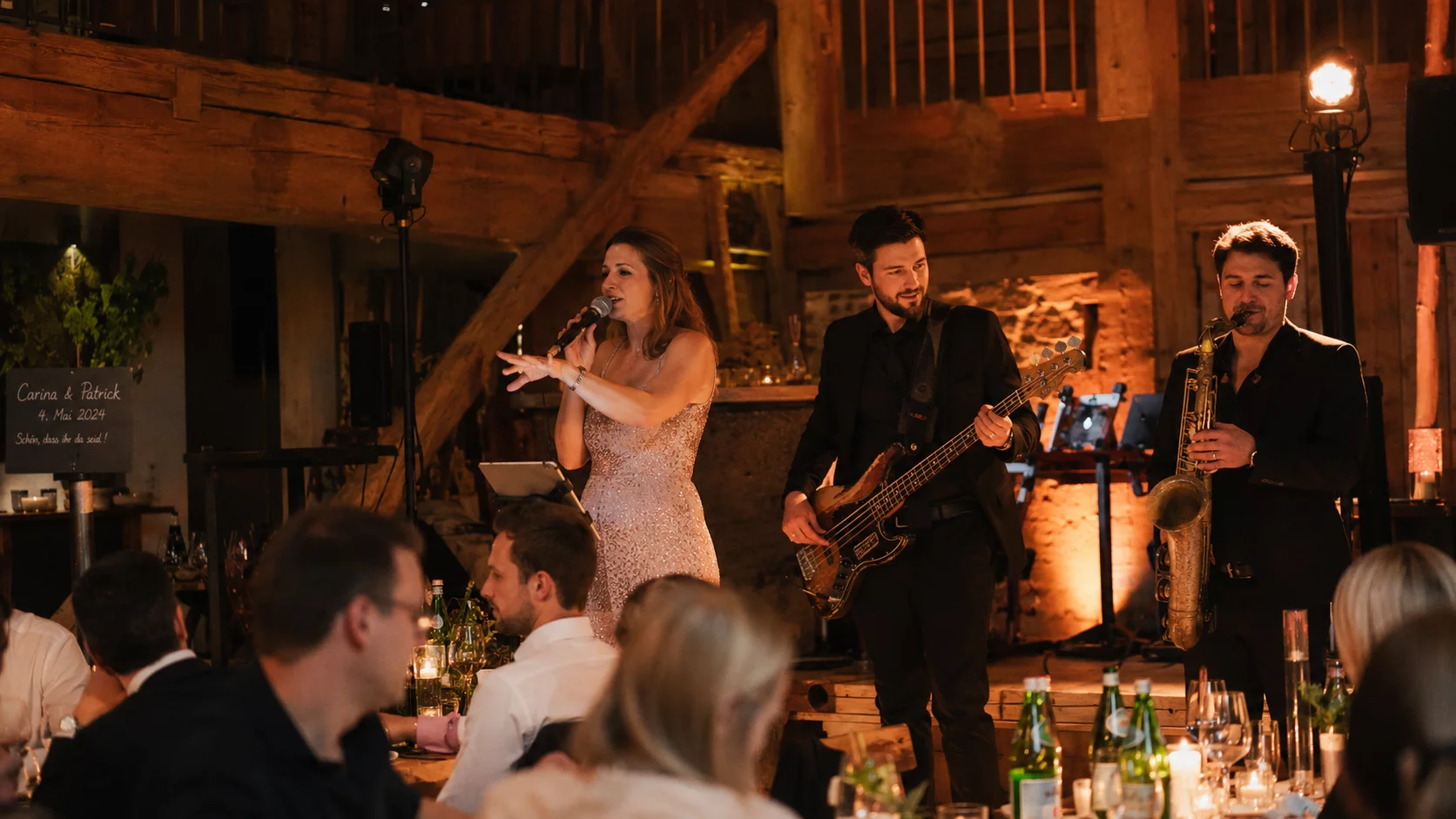 Kleine Live-Band mit Sängerin und Saxophonist beim Dinnerempfang auf einer Hochzeit in einer bayerischen Scheunenlocation